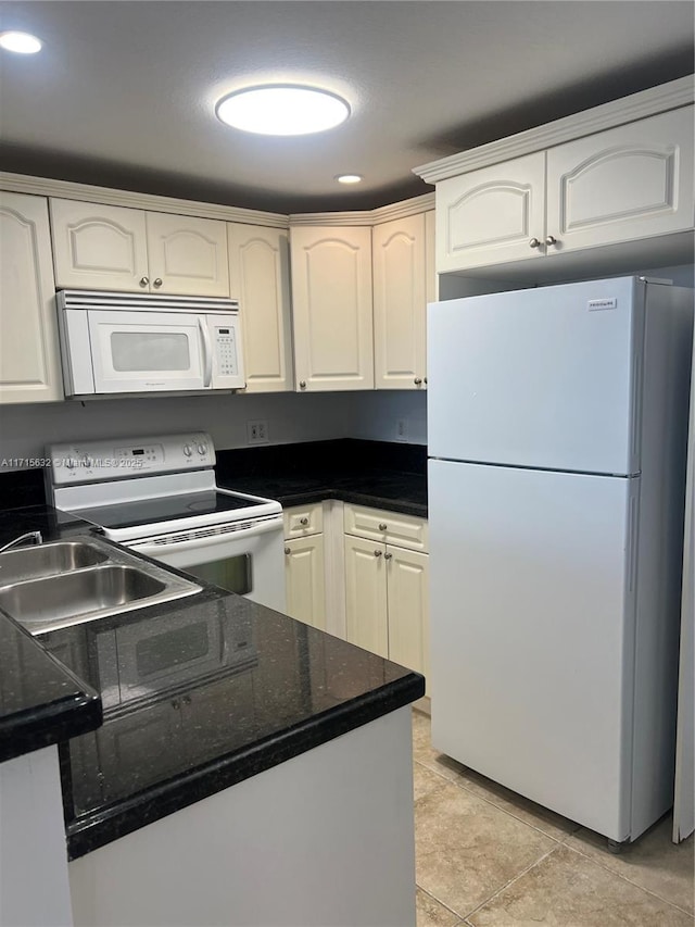 kitchen with white cabinets, light tile patterned flooring, white appliances, and sink