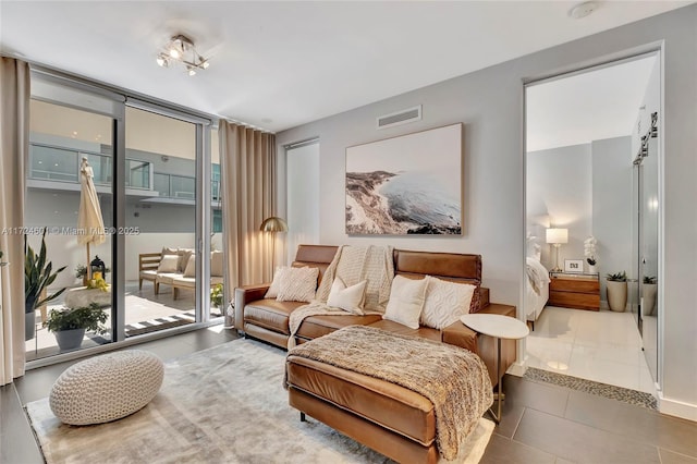 living area featuring expansive windows and tile patterned floors