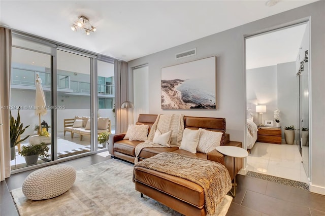 living area with expansive windows, a healthy amount of sunlight, and tile patterned floors