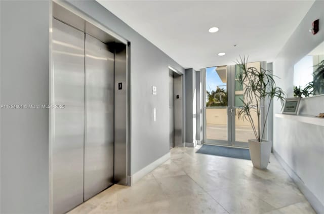 hallway featuring elevator and a wall of windows