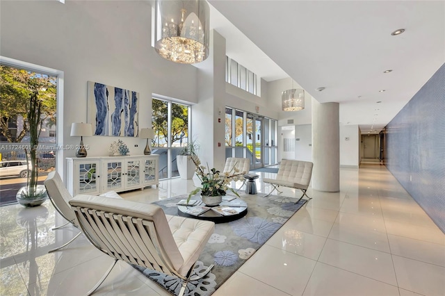 living room featuring a chandelier, a high ceiling, and light tile patterned floors