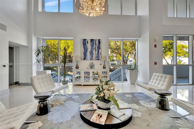 living room featuring an inviting chandelier, light tile patterned floors, and a high ceiling