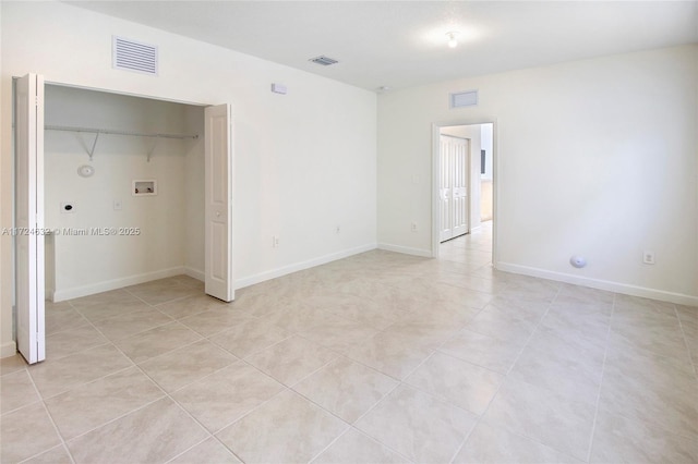 unfurnished bedroom featuring light tile patterned floors and a closet