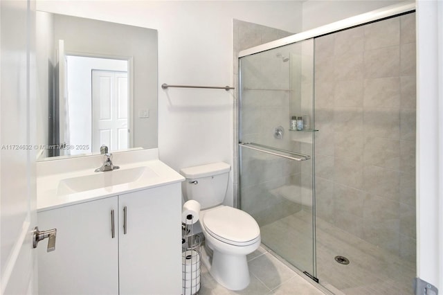 bathroom featuring tile patterned flooring, vanity, toilet, and walk in shower