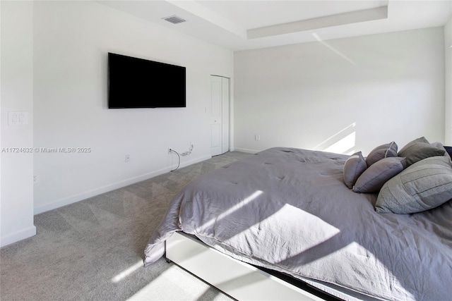 carpeted bedroom featuring a raised ceiling