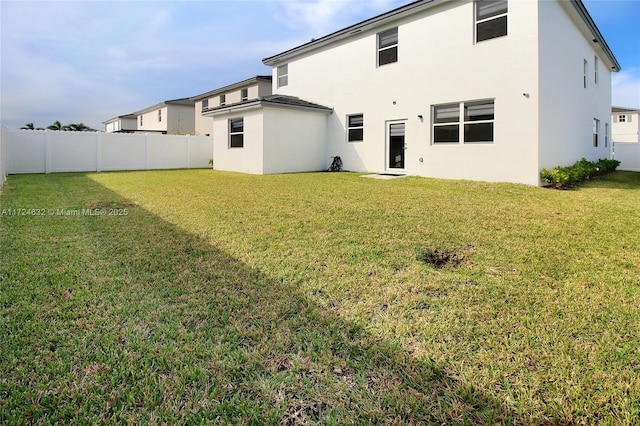 rear view of property with a yard