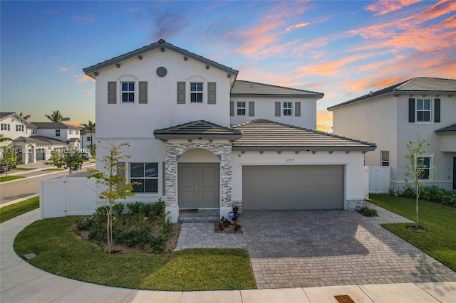 mediterranean / spanish-style house with a yard and a garage