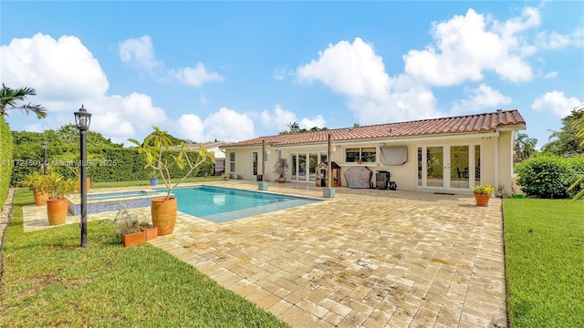 view of swimming pool featuring french doors, a patio area, and a lawn