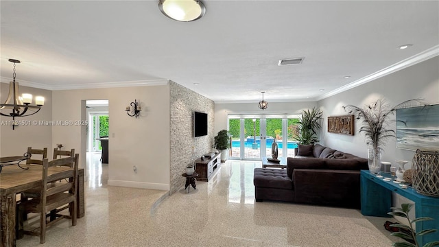 living room with crown molding and a chandelier