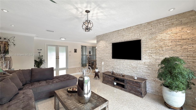 living room featuring a chandelier, ornamental molding, and french doors