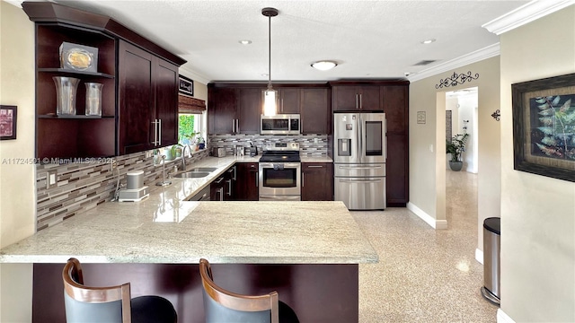 kitchen featuring kitchen peninsula, appliances with stainless steel finishes, a breakfast bar area, and sink