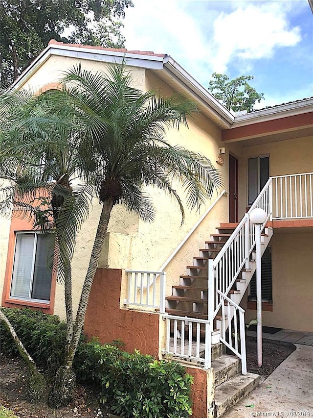 view of home's exterior with stucco siding and stairs