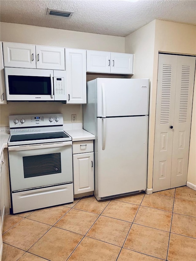 1024 Coral Club Dr Unit 1024, Coral Springs, FL 33071 - kitchen with white cabinets, light countertops, light tile patterned flooring, and white appliances