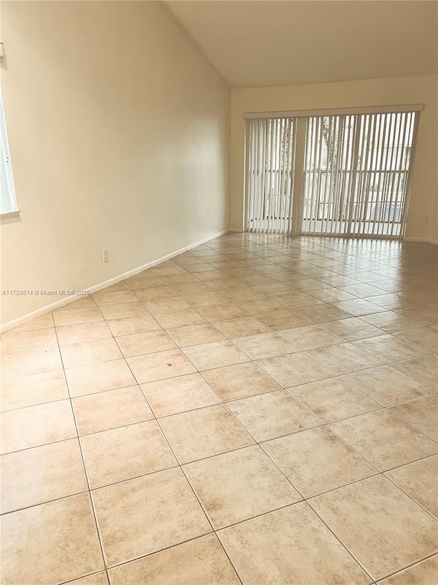 1024 Coral Club Dr Unit 1024, Coral Springs, FL 33071 - spare room featuring light tile patterned floors, baseboards, and lofted ceiling
