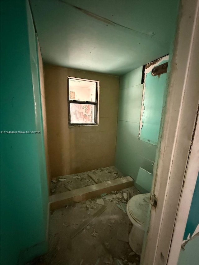 bathroom with walk in shower and toilet