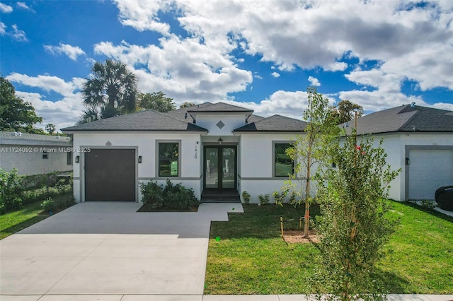 view of front of property featuring french doors, a front yard, and a garage