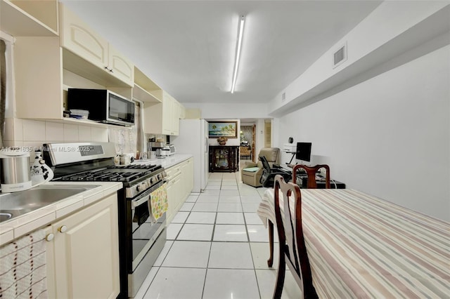 kitchen featuring tile countertops, stainless steel appliances, and light tile patterned flooring