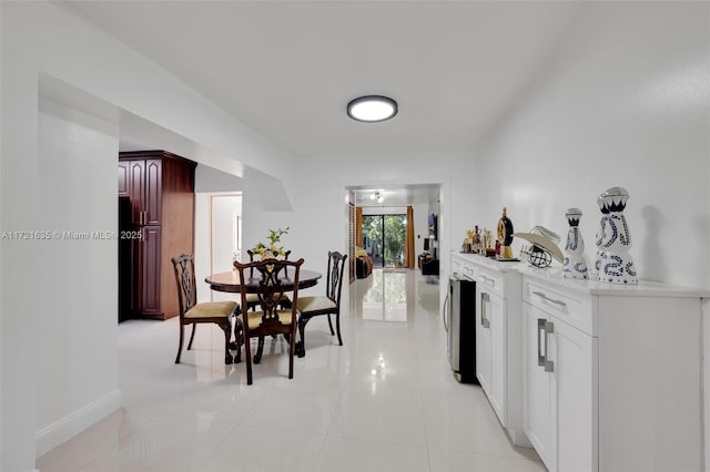 dining area with light tile patterned flooring and beverage cooler