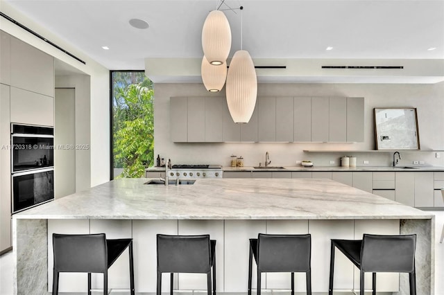 kitchen featuring a kitchen bar, multiple ovens, and a large island