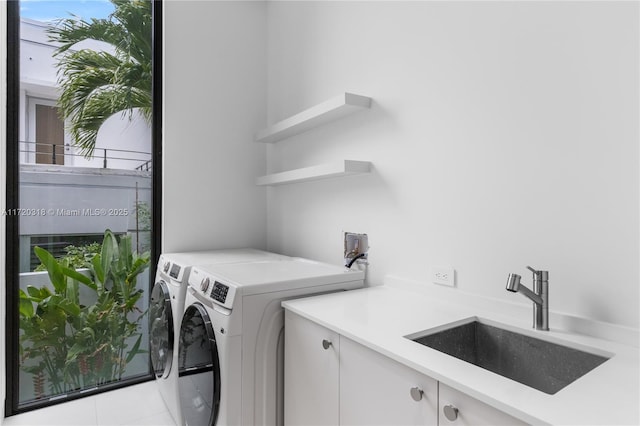 laundry room with cabinets, independent washer and dryer, light tile patterned flooring, and sink