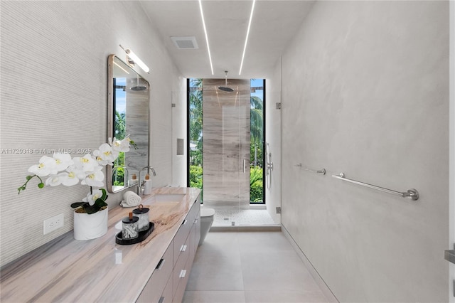 bathroom featuring vanity, toilet, floor to ceiling windows, and a shower with shower door