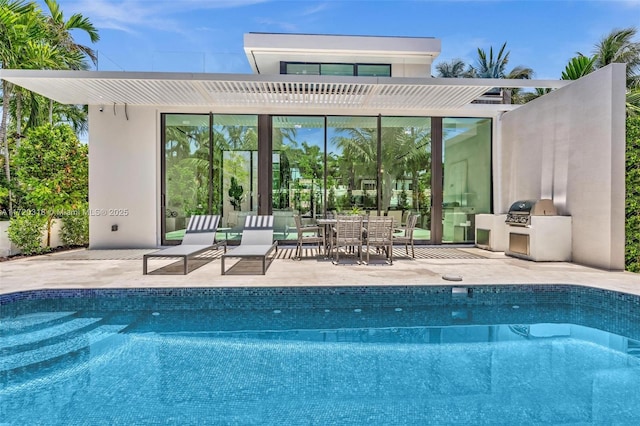 rear view of house featuring a pergola, area for grilling, and a patio area