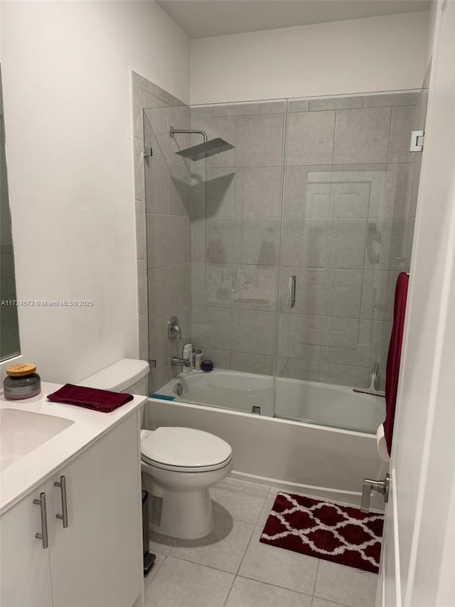 full bathroom featuring toilet, vanity, tile patterned floors, and enclosed tub / shower combo