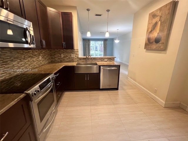 kitchen featuring pendant lighting, sink, tasteful backsplash, kitchen peninsula, and stainless steel appliances