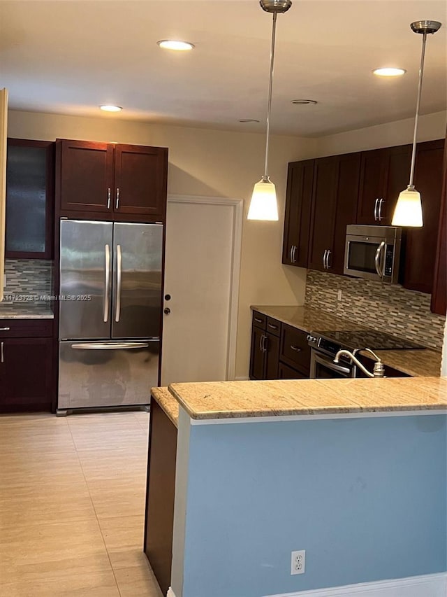 kitchen with kitchen peninsula, appliances with stainless steel finishes, and tasteful backsplash