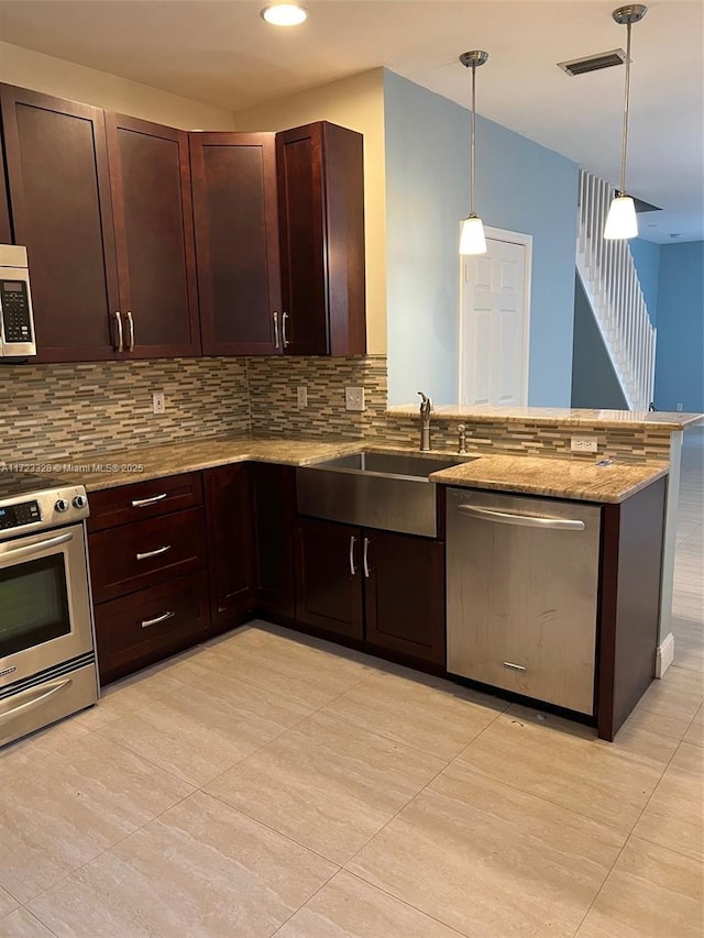 kitchen with kitchen peninsula, tasteful backsplash, stainless steel appliances, sink, and pendant lighting