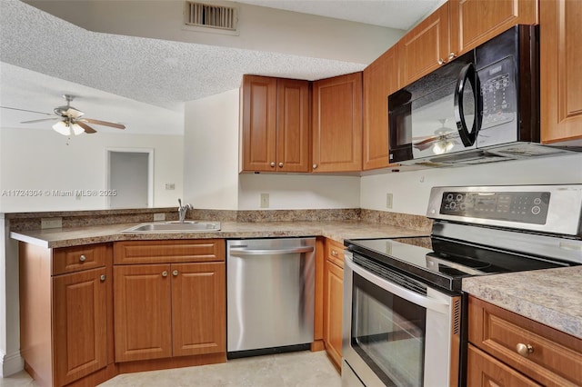 kitchen with ceiling fan, sink, a textured ceiling, light tile patterned flooring, and appliances with stainless steel finishes