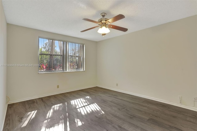 empty room with ceiling fan, dark wood-type flooring, and a textured ceiling