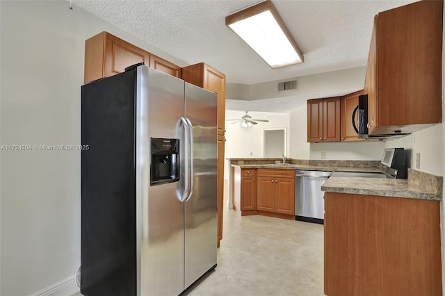 kitchen with ceiling fan, sink, a textured ceiling, and appliances with stainless steel finishes