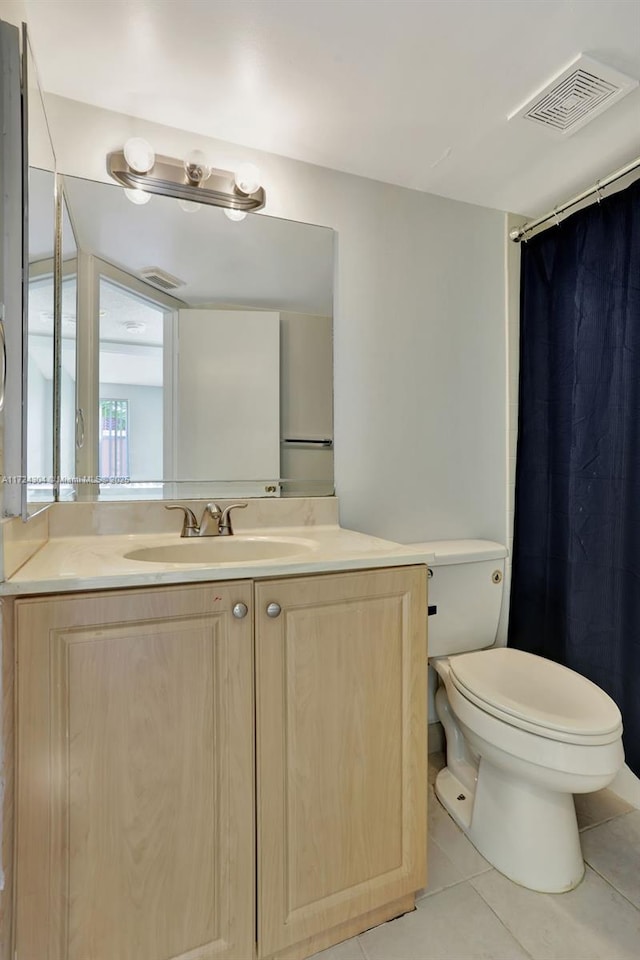 bathroom with tile patterned flooring, vanity, and toilet