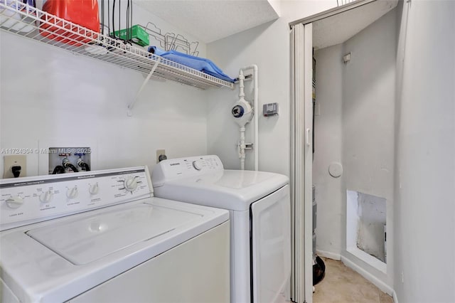 clothes washing area featuring separate washer and dryer and a textured ceiling