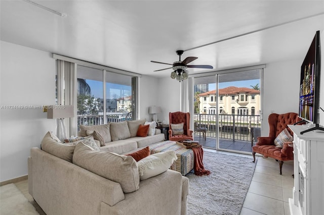 living room featuring ceiling fan, floor to ceiling windows, and light tile patterned floors