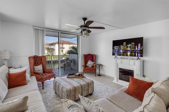 living room featuring ceiling fan, expansive windows, and light tile patterned floors