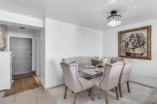 dining space featuring breakfast area, an inviting chandelier, and light tile patterned flooring