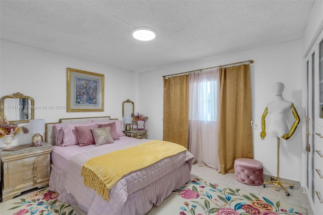 bedroom featuring light tile patterned floors and a textured ceiling