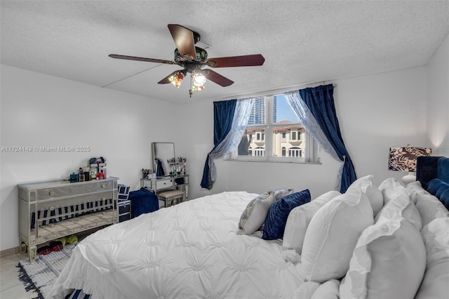 bedroom with a textured ceiling, ceiling fan, and light tile patterned flooring