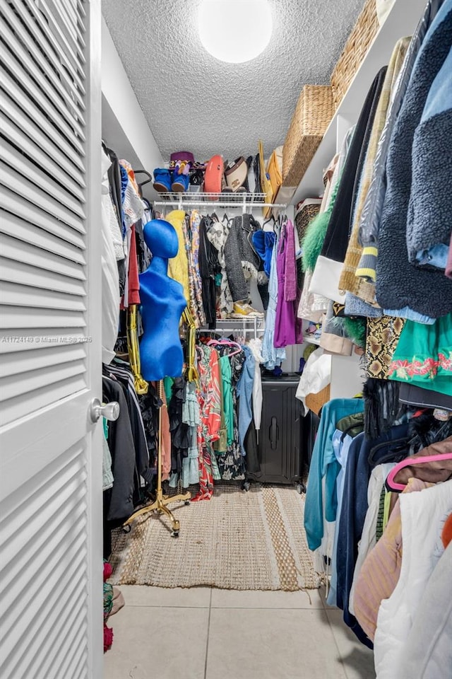 walk in closet with light tile patterned floors