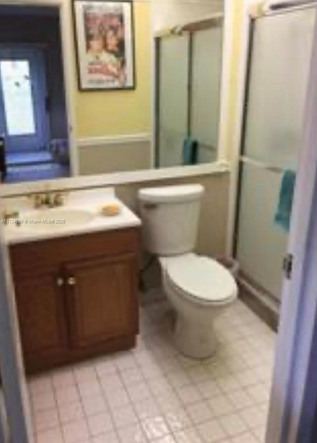 bathroom featuring tile patterned flooring, vanity, and toilet