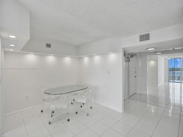 interior space with light tile patterned floors and a textured ceiling