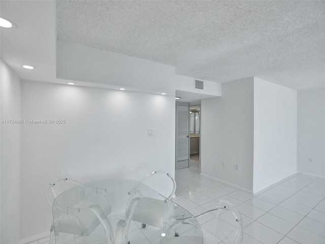 tiled empty room with a textured ceiling