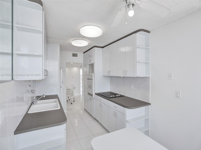 kitchen with ceiling fan, sink, tasteful backsplash, black electric stovetop, and white cabinets