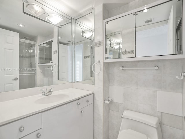 bathroom featuring vanity, an enclosed shower, tile walls, and toilet