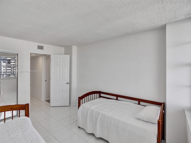 bedroom featuring light tile patterned floors and a textured ceiling