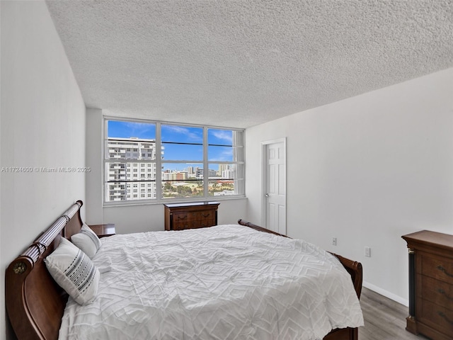 bedroom featuring hardwood / wood-style floors and a textured ceiling