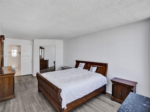 bedroom featuring light hardwood / wood-style floors and a textured ceiling