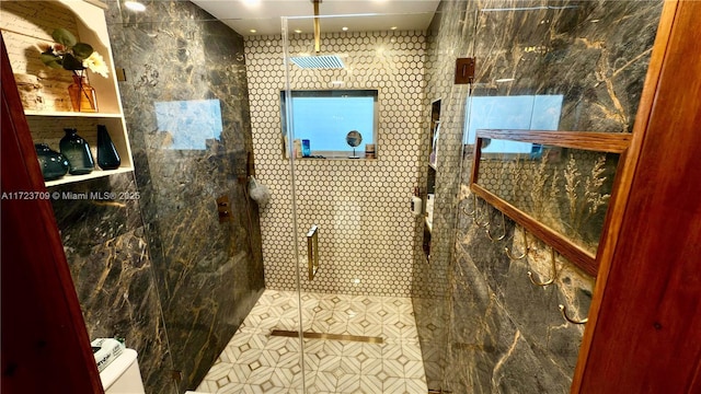 bathroom featuring tile walls, a shower with door, and toilet